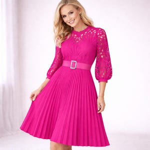 May include: A bright pink dress with a pleated skirt and a fitted bodice. The dress features a matching belt with a silver buckle and lace sleeves. The dress is knee-length and has a feminine, elegant style.