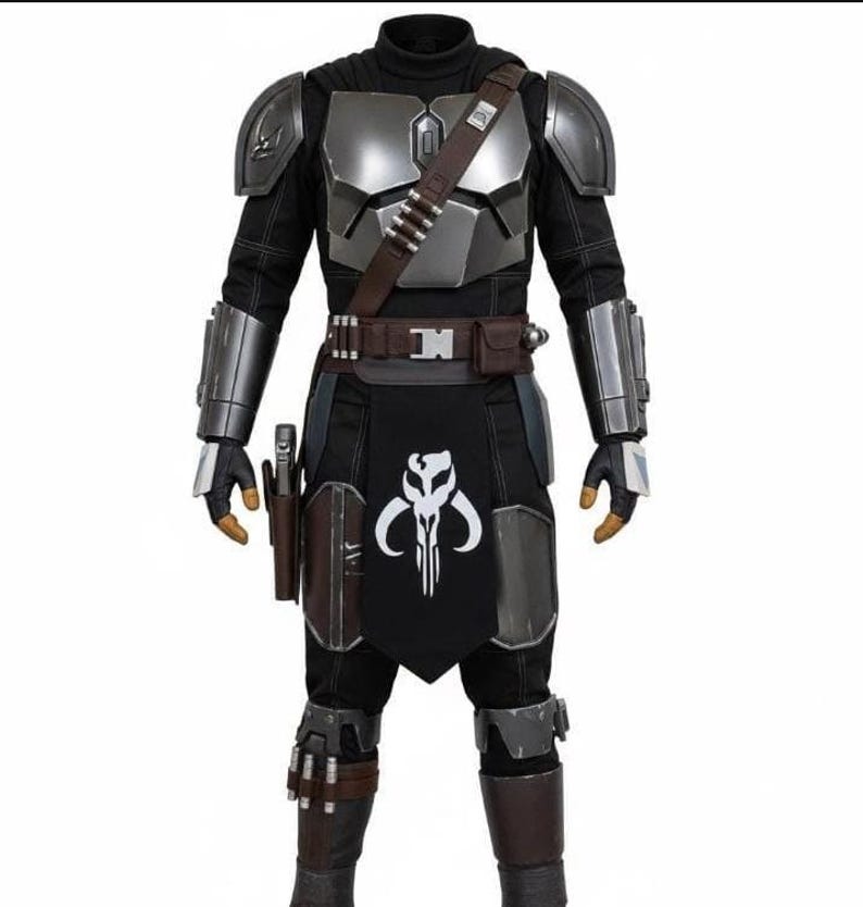 May include: A full-body costume featuring a black and silver color scheme. The costume includes a black turtleneck, silver chest and shoulder armor, and a black apron with a white skull emblem. A brown belt and holster complete the look.
