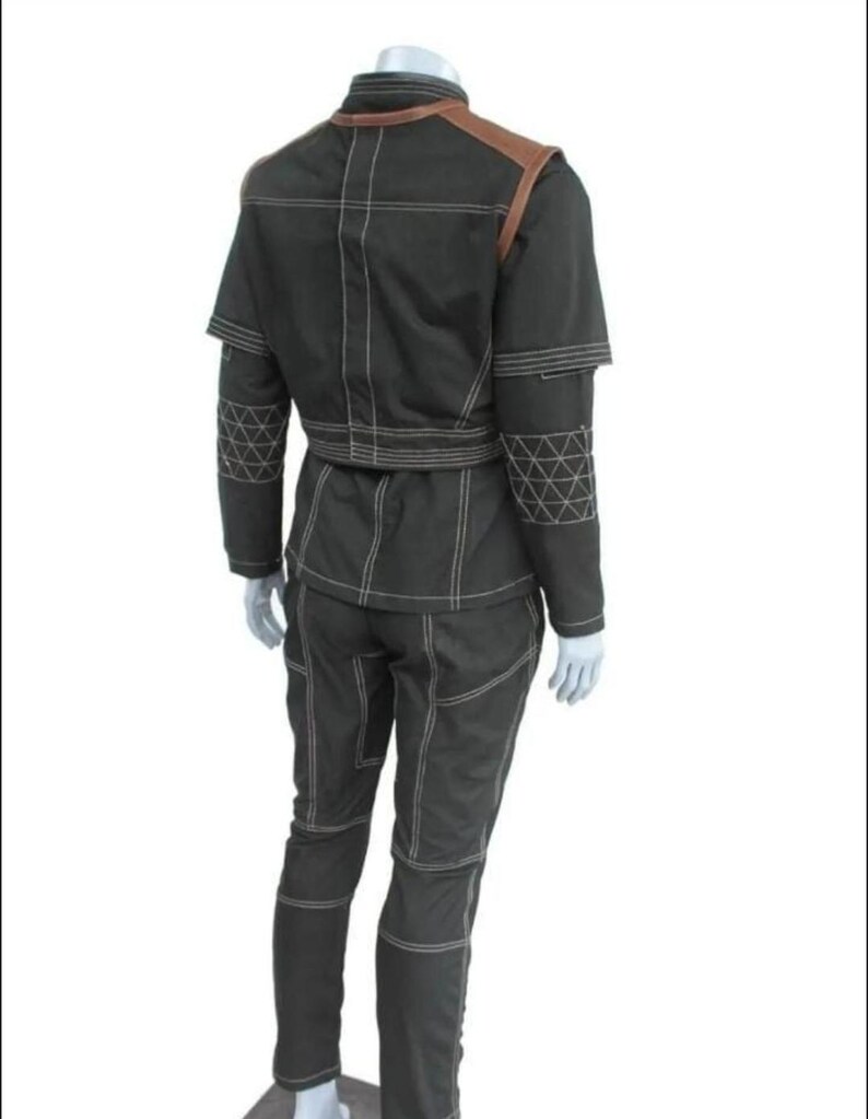 May include: A black two-piece outfit consisting of a jacket and pants with prominent white contrast stitching. The jacket features brown shoulder panels and a geometric triangular pattern on the sleeves. The pants have a matching seam design.
