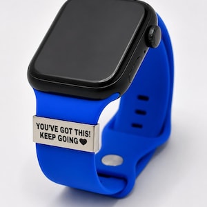May include: A black smartwatch with a blue silicone band. The watch face is rectangular. A silver metal plate on the band reads "YOU'VE GOT THIS! KEEP GOING ❤".