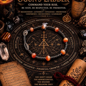 May include: A beaded bracelet featuring dark metallic beads and orange-toned spherical stones, centered on a circular mat with gold text reading OGUN'S LADDER, COMMAND YOUR RISE, BE SEEN, BE RESPECTED, BE PROMOTED, and various career-focused phrases.