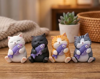 May include: Four small cat figurines in white, black, orange tabby, and gray tabby. Each cat is holding a purple fish. The cats are sitting on a wooden surface.