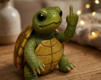 Puede incluir: Una figura caprichosa de una tortuga con cabeza y extremidades verdes, y caparazón amarillo y marrón. La tortuga está mostrando el dedo medio. La figura está sobre una superficie de madera.
