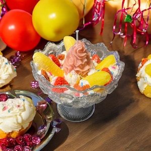 Könnte beinhalten: Eine weiße Keramik-Tasse mit schwarzem Henkel und dem Text "But First, Coffee" in schwarzer, handschriftlicher Schrift. Die Tasse steht auf einer weißen Oberfläche.