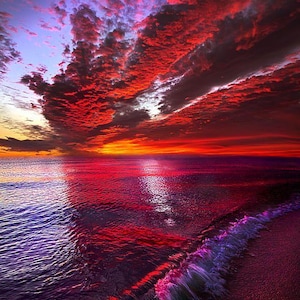 Peut inclure: Un coucher de soleil spectaculaire sur l'océan. Le ciel est rempli de nuages rouges et oranges flamboyants, se reflétant dans l'eau. Les vagues sont teintées de violet et de rose, créant un paysage marin coloré.
