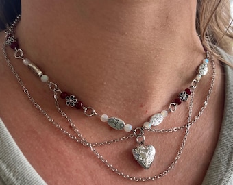 Secreto de Plata: Collar con medallón de plata, cadena de plata y cuentas florales.