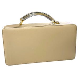 May include: A white ceramic mug with a black handle and the text "But First, Coffee" in a bold, black font. The mug is set against a blurred background, suggesting a cozy setting.