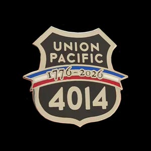 May include: A shield-shaped metal pin with a black background and silver trim. It features the text UNION PACIFIC in silver, a horizontal ribbon with the text 1776-2026 in red, white, and blue, and the large silver number 4014 at the bottom.
