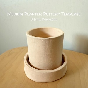May include: A light beige cylindrical ceramic planter with a matching circular saucer base. The text "MEDIUM PLANTER POTTERY TEMPLATE DIGITAL DOWNLOAD" is printed in white above the planter against a light background.