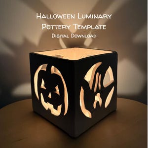 May include: A square ceramic luminary featuring cut-out jack-o'-lantern and ghost designs, illuminated from within. The text above reads: HALLOWEEN LUMINARY POTTERY TEMPLATE DIGITAL DOWNLOAD. The object casts shadows on the wall behind it.