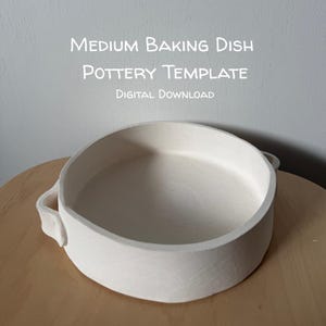 May include: A round, off-white ceramic baking dish with two side handles. The text above the dish reads: MEDIUM BAKING DISH POTTERY TEMPLATE DIGITAL DOWNLOAD. The dish has a smooth, matte surface and a simple, functional design for kitchen use.