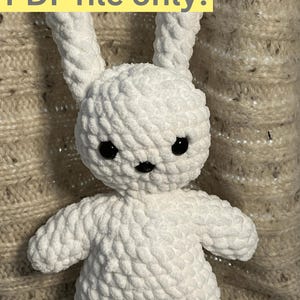 May include: A white, plush crochet bunny with black eyes and a black nose. The bunny has long ears and is made of a soft, textured yarn. Text at the top reads "PDF file only!"