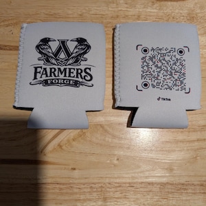 May include: Two white drinks insulators. One displays the text "FARMERS FORGE" with a logo of two ravens and a "W". The other has a QR code and the TikTok logo.
