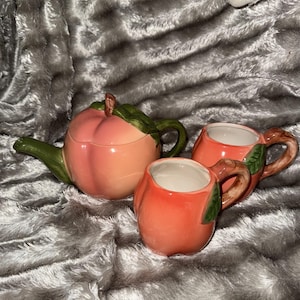 Tetera color melocotón y tazas a juego.