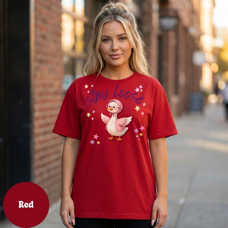 A woman wearing a red t-shirt with a cartoon duck and the text "Small Loose" printed on it.