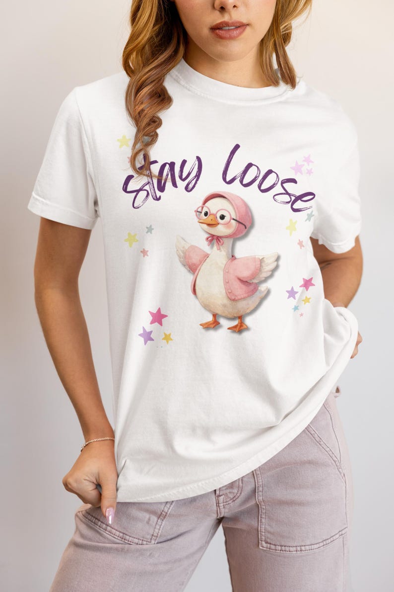 A woman wearing a white t-shirt with a cartoon duck and the text "Stay Loose" printed on it.