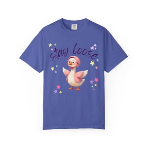 A blue t-shirt with a cartoon image of a duck wearing a pink hat and surrounded by stars. The text "STAY LOOSE" is written above the duck.