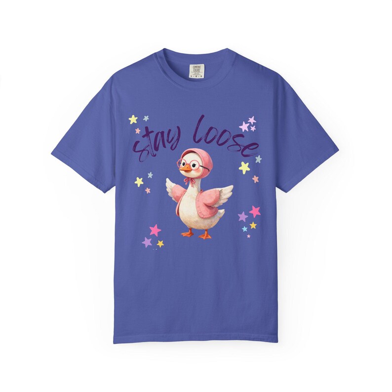 A blue t-shirt with a cartoon image of a duck wearing a pink hat and surrounded by stars. The text "STAY LOOSE" is written above the duck.