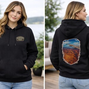 May include: Black hoodie with a front pocket and drawstring hood. The front features a gold and brown patch that reads "Window Seat Club". The back of the hoodie displays an image of an airplane wing over a landscape.