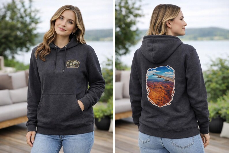 May include: Charcoal gray hoodie with a front pocket and a hood. The front features a patch with the text "WINDOW SEAT CLUB". The back displays a scenic graphic of a landscape. The model is wearing blue jeans.