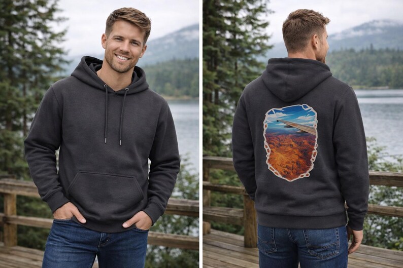 May include: Charcoal gray hoodie with a front pocket and drawstring hood. The back of the hoodie features a colorful graphic of a landscape scene. The model is wearing blue jeans.