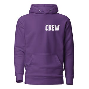 Peut inclure: Un sweat à capuche violet avec une poche avant et une capuche à cordon. Le mot "CREW" est imprimé en lettres blanches sur le haut de la poitrine gauche. Le sweat à capuche est fait d'une matière douce.