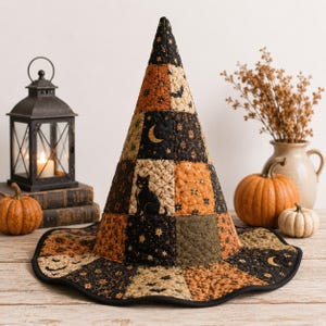 May include: A quilted witch hat featuring a patchwork design of black, orange, and olive green fabric squares. The fabric patterns include illustrations of black cats, crescent moons, stars, and bats. The hat has a tall, pointed cone and a wide brim.