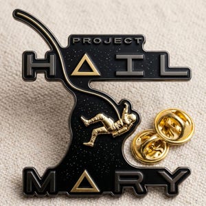 Puede incluir: Un pin de esmalte negro y dorado con el texto "PROJECT HAIL MARY". El pin presenta un astronauta con un traje espacial y dos respaldos dorados. Un accesorio único.