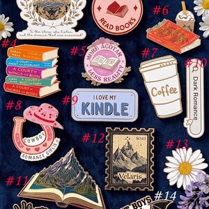May include: A collection of enamel pins with various designs, including a mountain landscape, a stack of books, a coffee cup, and the text "I Love My Kindle." The pins feature vibrant colors and intricate details, showcasing a range of themes.