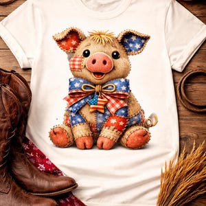 May include: A white t-shirt featuring a stuffed pig wearing a patriotic bow tie and patches. The pig has a pink snout, ears with star patterns, and is surrounded by cowboy boots, a hat, and wheat stalks on a wooden surface.