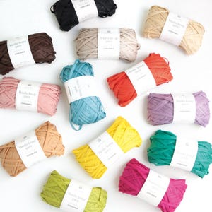 May include: A selection of colourful Manila hemp yarn skeins in shades like black, brown, beige, pink, blue, orange, purple, yellow, green, and fuchsia. Each skein is labelled with "Manila hemp yarn".