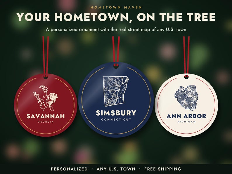 May include: Three circular ornaments with red ribbons. The red ornament features a white map of Savannah, Georgia. The blue ornament shows a white map of Simsbury, Connecticut. The white ornament displays a blue map of Ann Arbor, Michigan.