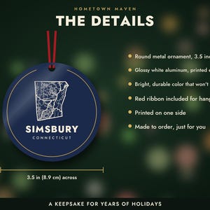 May include: A round, dark blue metal ornament measuring 3.5 inches across, featuring a white map outline of Simsbury, Connecticut, with the text 'SIMSBURY CONNECTICUT' below. It includes a red ribbon for hanging and is printed on one side.