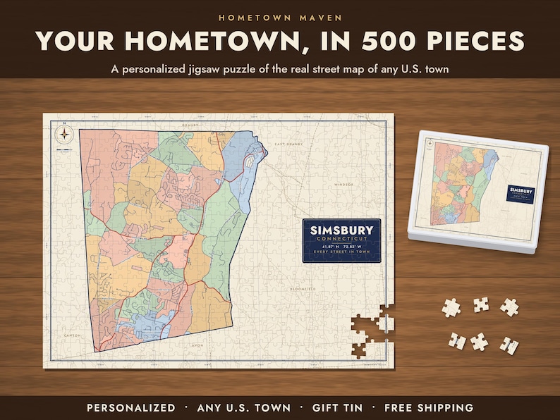 Op de afbeelding: Een gepersonaliseerde legpuzzel met een wegenkaart van Simsbury, Connecticut, met gekleurde secties op een cr&egrave;mekleurige achtergrond. De puzzel bevat een bijpassende doos en losse stukjes met de tekst: HOMETOWN MAVEN YOUR HOMETOWN, IN 500 PIECES.