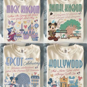May include: Four cream-colored t-shirts featuring Disney park themes. The shirts display graphics of Mickey Mouse, park landmarks, and text including Magic Kingdom, Animal Kingdom, Epcot, and Hollywood, with slogans like Where The Young At Heart Can Laugh And Play.