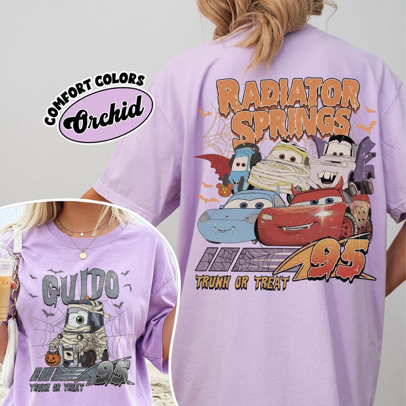 May include: Orchid Comfort Colors t-shirt with a Halloween design featuring characters from the film Cars. The back of the shirt says "Radiator Springs" and "Trunk or Treat". The front of the shirt features the character Guido.