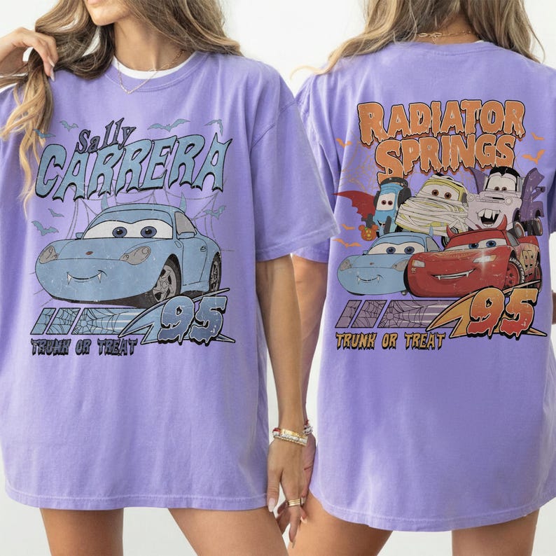 May include: A lilac t-shirt with a graphic of Sally Carrera from the film Cars, with the text "Sally Carrera" and "95". The back of the shirt shows "Radiator Springs" and other Cars characters in a Halloween theme.
