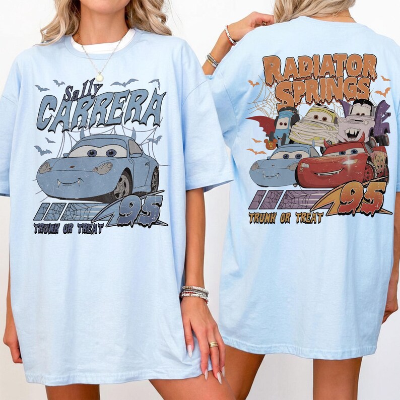 May include: Pale blue t-shirt with a graphic of Sally Carrera from the film Cars, with the text "Sally Carrera" and "Trunk or Treat". The back of the shirt displays "Radiator Springs" and other Cars characters.