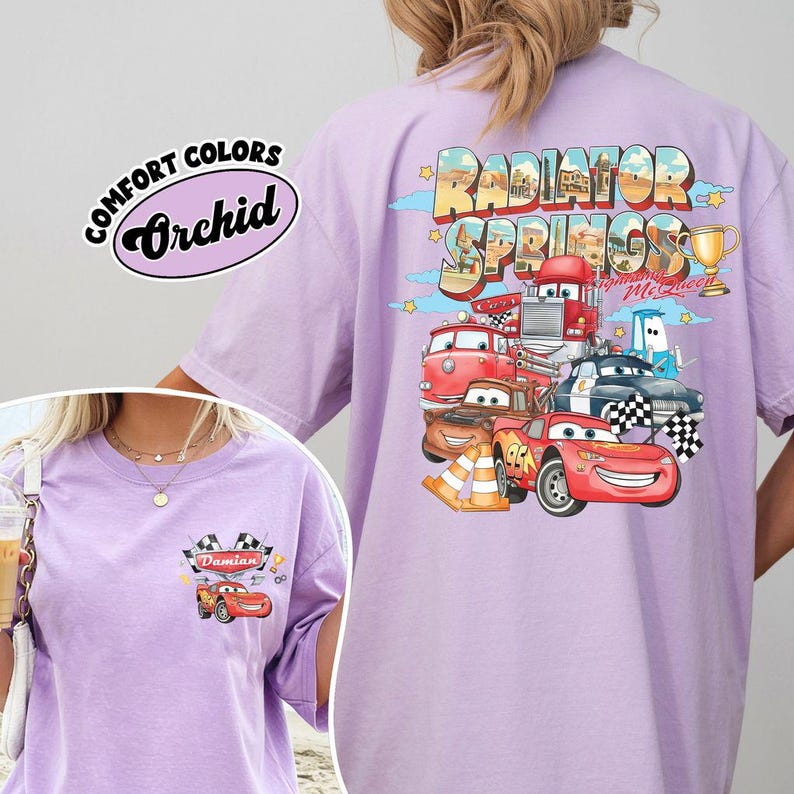 Puede incluir: Una camiseta de color lila claro con un gr&aacute;fico de personajes de dibujos animados y el texto "Radiator Springs" y "Lightning McQueen". La camiseta tambi&eacute;n tiene el texto "Comfort Colors Orchid".
