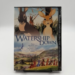 May include: A Watership Down DVD case featuring an animated illustration of two large rabbits in the foreground and a group of smaller rabbits in a grassy landscape below. The text reads Watership Down and From the novel that enthralled the world comes an animation classic.