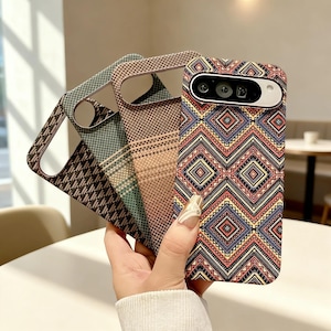 Può includere: Una collezione di custodie per telefoni con vari motivi geometrici. Le custodie presentano disegni nei toni del marrone, blu e rosso. Una custodia mostra un vivace motivo a zig-zag con un ritaglio per la fotocamera.