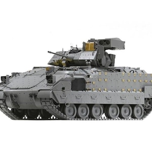 May include: A gray armored fighting vehicle with a rotating turret, multiple weapons, and a tracked chassis. The vehicle has a boxy design with numerous rivets and details, and is set against a white background.