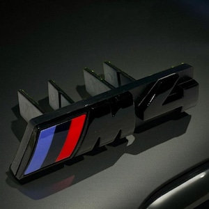 M4-grillebadge: zwart glanzend embleem (8,5 cm), accessoire met performance-logo