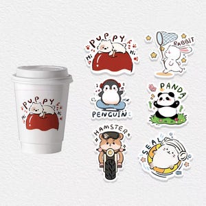 May include: A white paper coffee cup with a lid, featuring a sticker of a puppy on a red apple. Surrounding the cup are stickers of a rabbit, panda, penguin, hamster, and seal, each with unique designs and text.