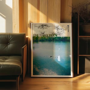 Puede incluir: Una impresión de arte mural rectangular enmarcada que muestra una escena de lago sereno con un pato nadando en el agua. La parte superior muestra una imagen de bosque en blanco y negro con la palabra DEVOTION en letras verdes y texto coreano.