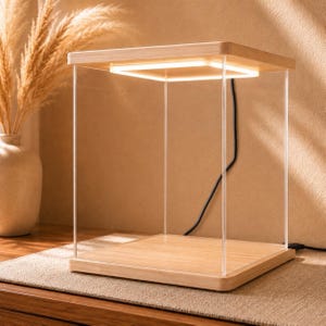 May include: A square display case featuring a light-colored wooden base and top, connected by four clear acrylic vertical supports. An integrated square LED light strip is recessed into the underside of the wooden top, casting a warm glow downward.