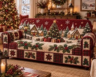 May include: A quilted sofa cover featuring a festive winter village scene with snow-covered houses, pine trees, and a central Christmas tree. The design includes red and green plaid borders, holly leaf patterns, and pinecone motifs.