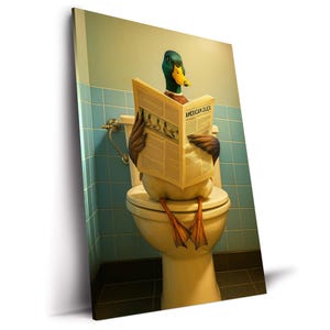 以下が含まれることがあります： 「AMERICAN DUCK」というタイトルの新聞を読みながらトイレに座っているアヒルのユーモラスなプリント。アヒルは緑と黒の羽、黄色のくちばし、オレンジ色の足を持っています。背景は水色のタイルの壁です。