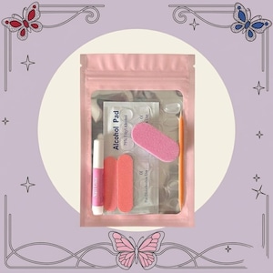 May include: A pink resealable pouch containing a nail application kit. Inside are a small tube of nail glue, two rectangular pink nail files, one oval pink nail buffer, an orange wooden cuticle stick, and a packet labeled Alcohol Pad.