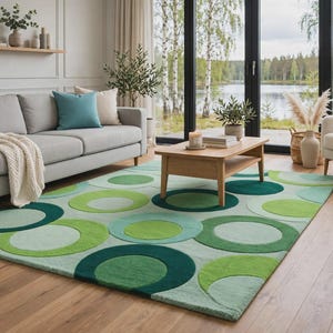 Op de afbeelding: Een rechthoekig vloerkleed met een herhalend patroon van overlappende cirkels in diverse groentinten, waaronder limoen, bosgroen en mint. Het ontwerp bestaat uit effen gekleurde cirkelvormen die over een lichtgroene achtergrond zijn gelegd.